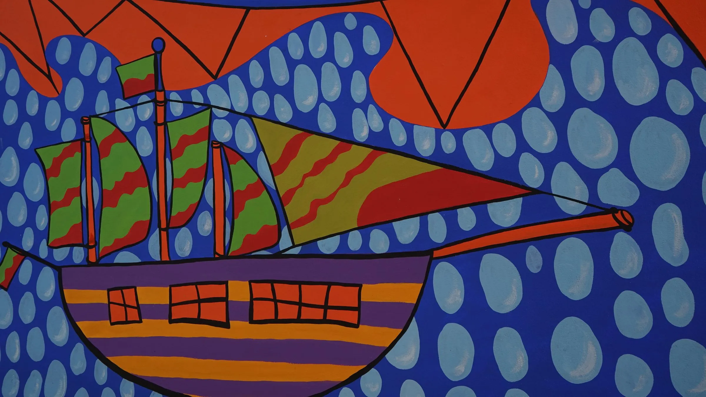 Mural de un barco de colores vivos pintado por estudiantes