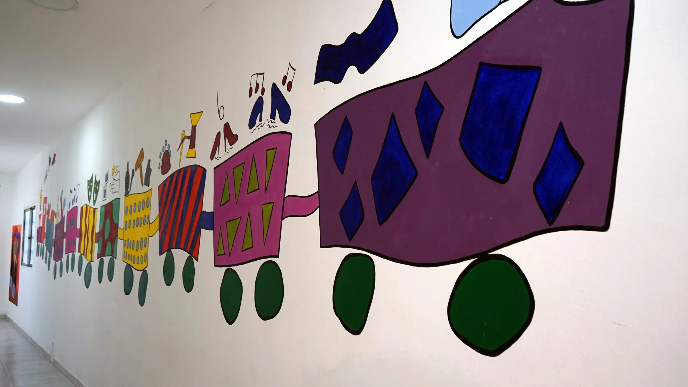 Pasillo del Instituto con una secuencia de murales de estudiantes